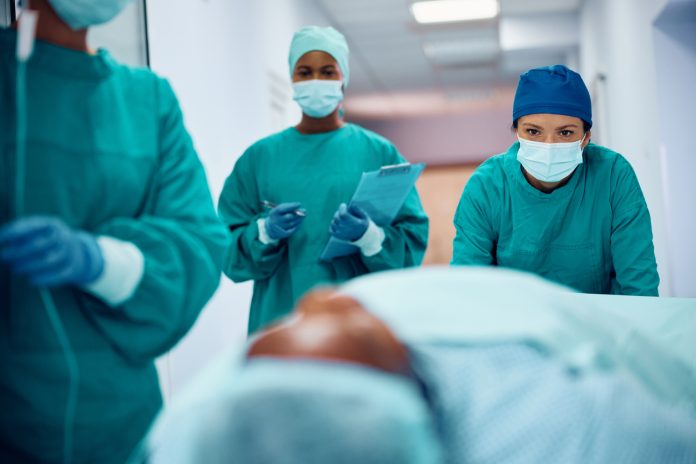 Female team of surgeons taking patient out of the operating room