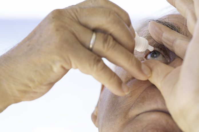 Mature Man Using Eye Drops