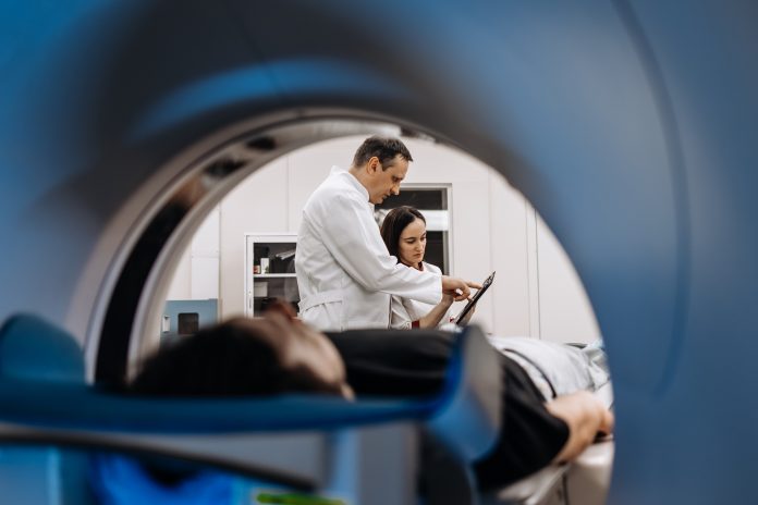 n a bright diagnostic center, a young man undergoes a CT or MRI scan using modern equipment. This image reflects the forefront of medical technology, emphasizing precision and patient care.