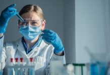 A dedicated scientist is conducting a detailed experiment within a wellequipped laboratory, utilizing various test tubes and a precision pipette for their meticulous research work
