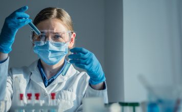 A dedicated scientist is conducting a detailed experiment within a wellequipped laboratory, utilizing various test tubes and a precision pipette for their meticulous research work