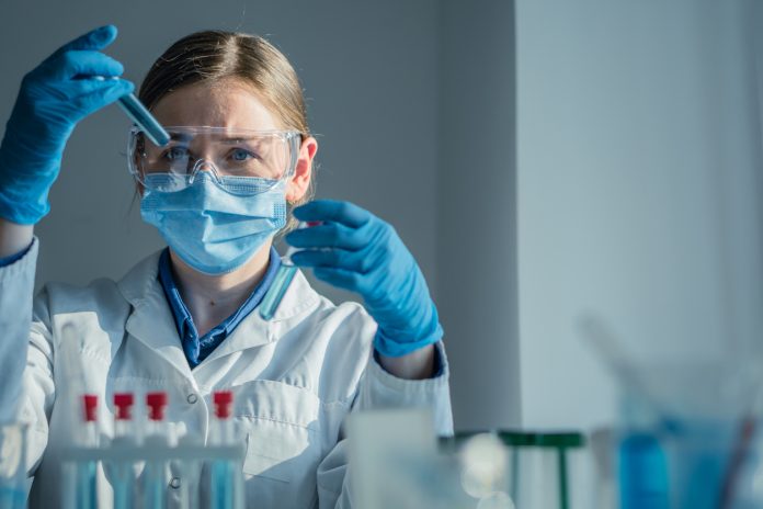 A dedicated scientist is conducting a detailed experiment within a wellequipped laboratory, utilizing various test tubes and a precision pipette for their meticulous research work