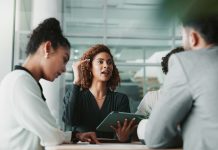 Woman, lawyer and tablet at meeting with team, planning and discussion for review for legal case in office. People, attorney and digital touchscreen with group, negotiation and feedback at law firm