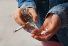 Girl holding vodka,pills and cigarettes