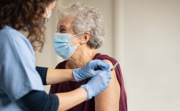 Doctor giving Covid vaccine to senior woman