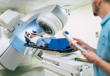 Cancer treatment in a modern medical private clinic or hospital with a linear accelerator. Professional doctors team working while the woman is undergoing radiation therapy for cancer