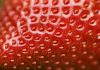Detailed surface shot of a fresh ripe red strawberry.