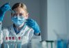 In a hightech lab, a dedicated scientist in a lab coat conducts a complex experiment with a pipette, surrounded by colorful test tubes of reactive substances, showcasing scientific exploration