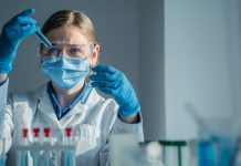 In a hightech lab, a dedicated scientist in a lab coat conducts a complex experiment with a pipette, surrounded by colorful test tubes of reactive substances, showcasing scientific exploration