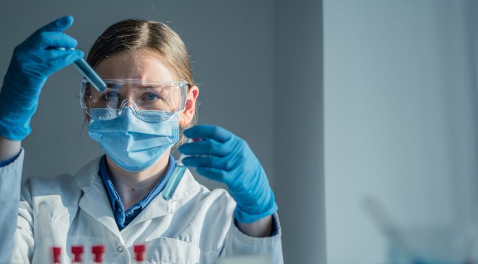 In a hightech lab, a dedicated scientist in a lab coat conducts a complex experiment with a pipette, surrounded by colorful test tubes of reactive substances, showcasing scientific exploration