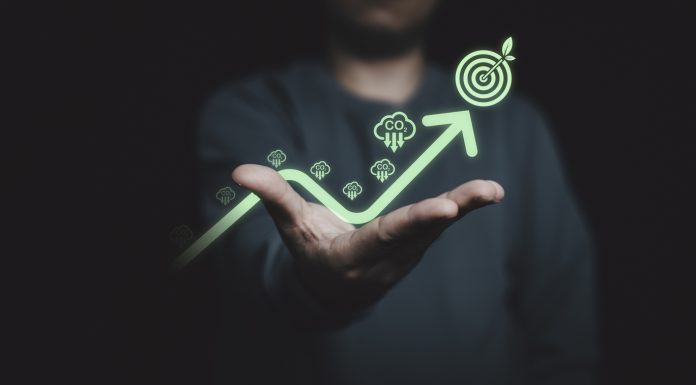 Glowing of green up arrow with carbon reduction on businessman until achievement environment target for decrease CO2 , carbon footprint and carbon credit to limit global warming from climate change.
