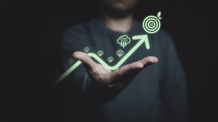 Glowing of green up arrow with carbon reduction on businessman until achievement environment target for decrease CO2 , carbon footprint and carbon credit to limit global warming from climate change.