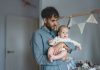 Father on paternity leave looking after his infant son at home