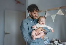 Father on paternity leave looking after his infant son at home