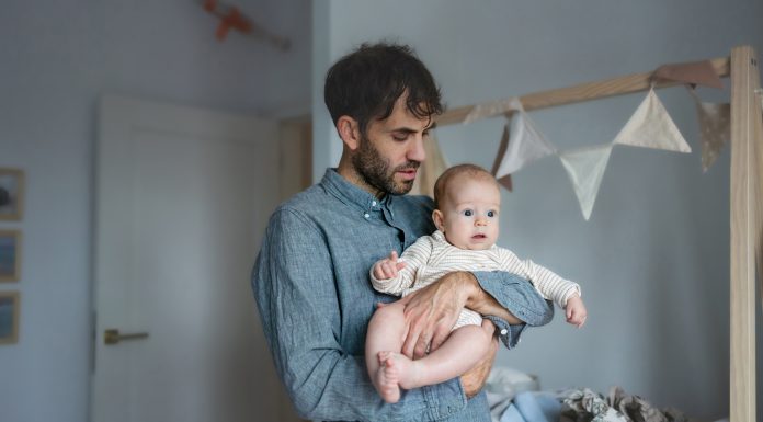 Father on paternity leave looking after his infant son at home