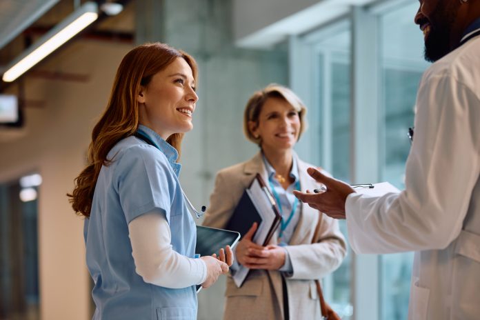 Happy nurse on a meeting with hospital administrator and doctor.