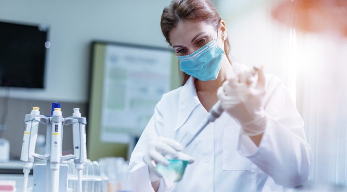Woman in laboratory, examining new potions for the scientific research at university. Woman is wearing protective mask and protective gloves (Surgical gloves) while working with beakers, test tubes and other lab equipment. Series of images, taken with Nikon D800 and 50mm or 85 mm professional lens, developed from RAW.