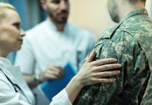 Close up of doctors consoling military officer in the hospital.