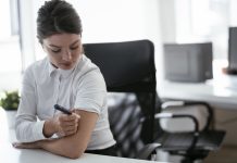 Workplace challenges affect 40% of employees living with diabetes Businesswoman is giving herself an injection of insulin.
