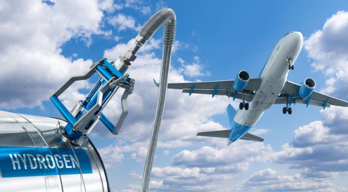 Fuel nozzle with the inscription Hydrogen on a background of airplane and blue sky. Clean mobility concept