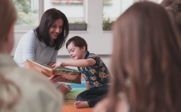 Reading time in an elementary school or kindergarten, a teacher reads a book to children in an elementary school or kindergarten. The concept of pre-school education. Selective focus