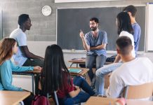 As classroom mental health cases rises, so must early and proactive intervention Teenager students and young male teacher sharing group discussion at School