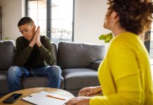 Youth suicide: An overview Selective focus shot of mid adult female therapist giving constructive advice to insecure teenage boy, that is struggling with negative emotions, sitting across from her on the sofa, during a therapy session.