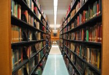 A view of the stacks in the main library at Connecticut College. With a line of lights parrel to the stacks.