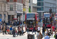 City of London, lots of people walking at Bishop's gate street, buses, taxis and cars on the road