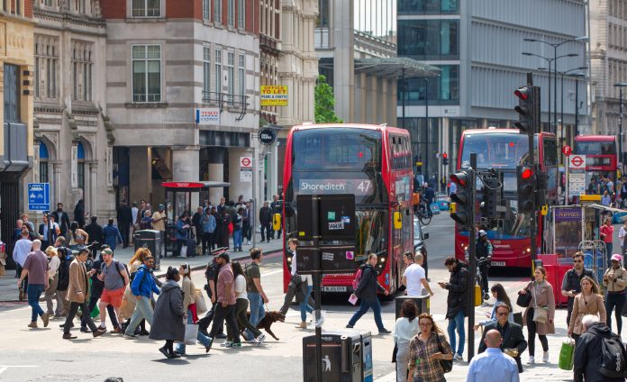 City of London, lots of people walking at Bishop's gate street, buses, taxis and cars on the road