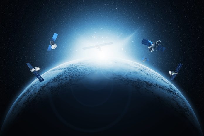 Artificial Satellites Orbiting Earth in Space with Sunrise on the Horizon and Starry Background