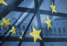 A transparent European Union flag obscures partly a building