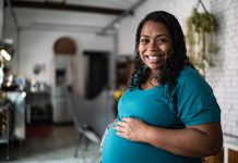 Reproductive longevity and public policy: Aligning biology with modern life Portrait of a pregnant woman touching her belly at home