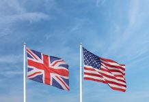Waving English and American flag in front of a blue sky