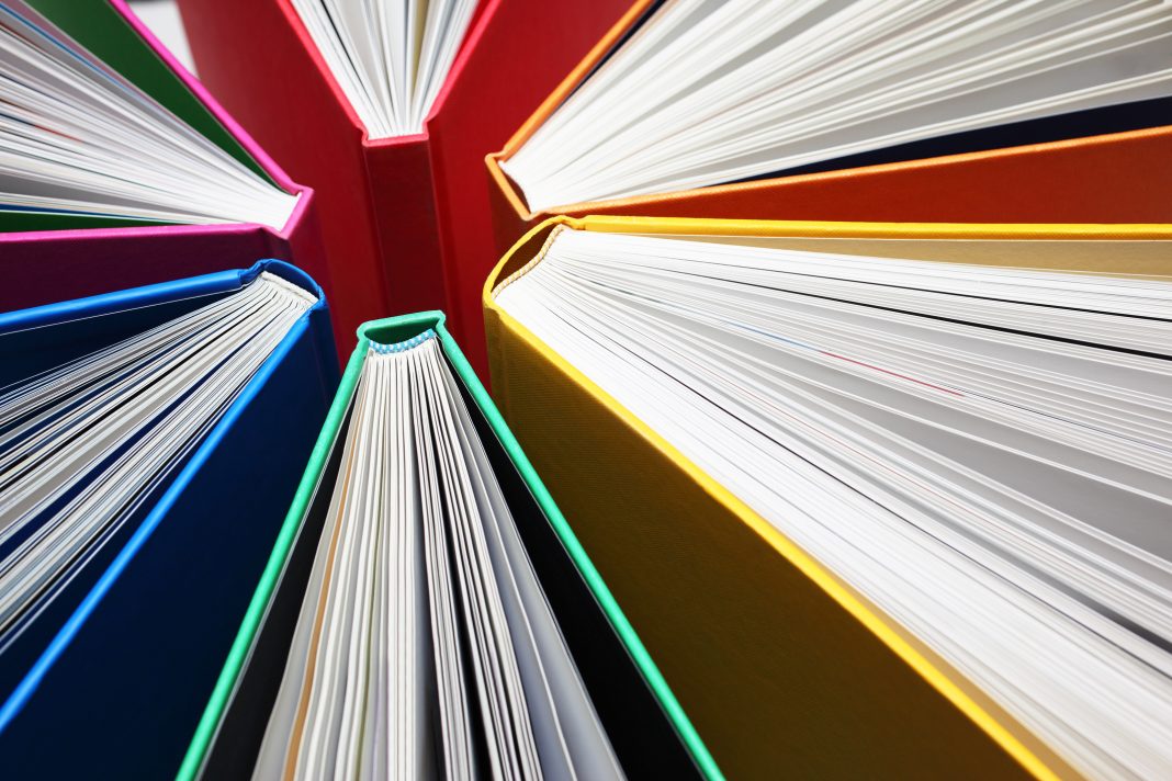 Fanned out colorful books forming light-beam like shape.