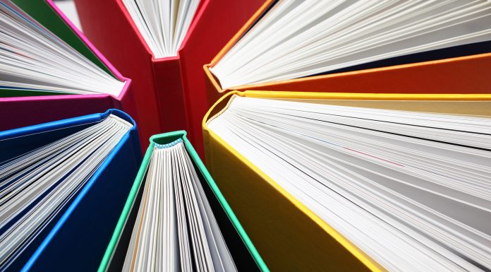 Fanned out colorful books forming light-beam like shape.