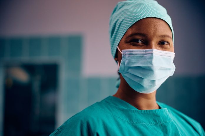 Happy black surgical nurse looking at camera.