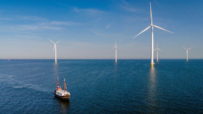 Windmill turbines at sea seen from a drone aerial view from abov