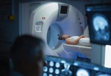 In Medical Laboratory Patient Undergoes MRI or CT Scan Process, in Control Room Doctor Watches Procedure and Monitors with Brain Scans Results. Healthcare Facility with High-Tech Equipment