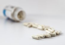 Lithium supplements to prevent Alzheimer’s disease: A poisoned chalice? selective focus photo of lithium orotate capsules, poured out of the jar. dietary concept. dietary supplement limited depth of field photo