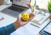 Emoticon ball on male hand on work table.happy life concepts.inspiration and motivation idea
