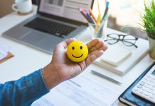 Emoticon ball on male hand on work table.happy life concepts.inspiration and motivation idea
