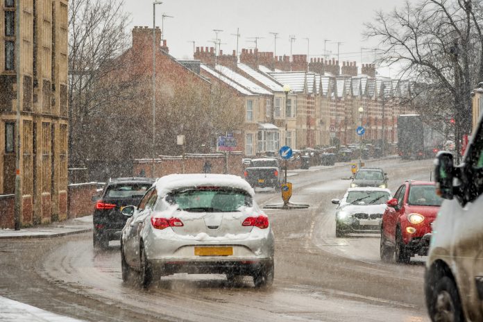 Moving road traffic while snowing in england uk