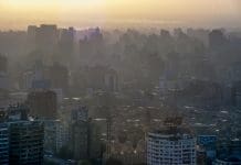 scanned historical colour photo of downtown Cairo with houses in the haze and backlighting