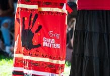 Indigenous gender-based violence: I am not murdered, but parts of me are missing Sacramento, CA, U.S.A. - Sept. 26, 2025: Close up of a skirt combining an Every Child Matter message with a Missing and Murdered handprint symbol on red taken at the State Capitol public park area.
