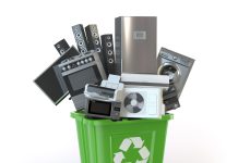 Old kitchen appliances in the rubbish bin isolated on white. Time to change home technics. Recycling concept. 3d illustration