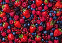 Forest fruit berries overhead assorted mix in studio on dark background with raspberries, blackberries, blueberries, red currant.