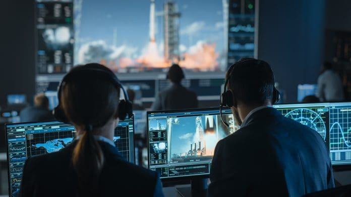 Group of People in Mission Control Center Witness Successful Space Rocket Launch. Flight Control Employees Sit in Front Computer Displays and Monitor the Crewed Mission.