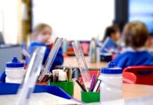 School classroom scene with kids learning in background